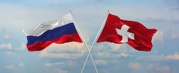 ロシアとスイスの旗は 晴れた日に雲と空に対して旗竿に風に振っています 関係を象徴し 両国間の対話 3Dイラスト — ストック写真