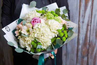 Rengarenk çiçek buketi tutan bir kadın. Taze, yemyeşil renkli çiçekler.