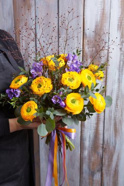 Rengarenk çiçek buketi tutan bir kadın. Taze, yemyeşil renkli çiçekler.