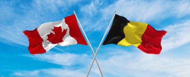 Kanada ve Belçika 'nın ulusal bayraklarını aştı bulutlu gökyüzünde rüzgarda dalgalanıyor. İlişkiyi, diyaloğu, iki ülke arasında seyahat etmeyi sembolize ediyor. Boşluğu kopyala