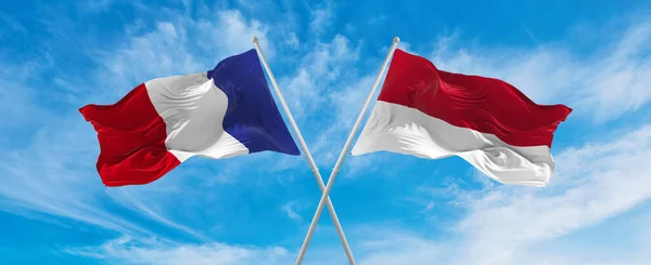 雲の多い空に フランスとインドネシアの国旗が風になびいていました 両国間の旅行を象徴する スペースのコピー — ストック写真