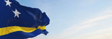 Curacao 'nun resmi bayrağı bulutlu arka planda, günbatımında, panoramik manzarada. Vatansever ve seyahat kavramı. Geniş afiş afiş için boşluk kopyala. 3d illüstrasyon