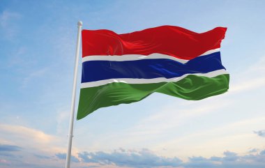 Gambiya 'nın resmi bayrağı bulutlu arka planda, günbatımında, panoramik manzaralı. Vatansever ve seyahat kavramı. Geniş afiş afiş için boşluk kopyala 