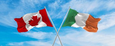 Kanada ve İrlanda 'nın ulusal bayraklarını aştı bulutlu gökyüzünde rüzgarda dalgalanan bayrak. İlişkiyi, diyaloğu, iki ülke arasında seyahat etmeyi sembolize ediyor. Boşluğu kopyala