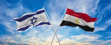 İsrail ve Mısır bayraklarını aşıp bulutlu gökyüzünde rüzgarda dalgalanan bayrak. İlişkiyi, diyaloğu, iki ülke arasında seyahat etmeyi sembolize ediyor. Boşluğu kopyala