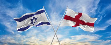 İsrail ve İngiltere 'nin ulusal bayraklarını aştı bulutlu gökyüzünde rüzgarda dalgalanan bayrak. İlişkiyi, diyaloğu, iki ülke arasında seyahat etmeyi sembolize ediyor. Boşluğu kopyala