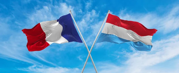 曇り空の中フランス国旗とルクセンブルク国旗が風になびいていました 両国間の旅行を象徴する スペースのコピー — ストック写真