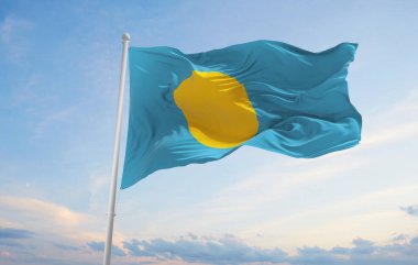 Palau 'nun resmi bayrağı bulutlu arka planda, günbatımında, panoramik manzara. Vatansever ve seyahat kavramı. Geniş afiş afiş için boşluk kopyala 