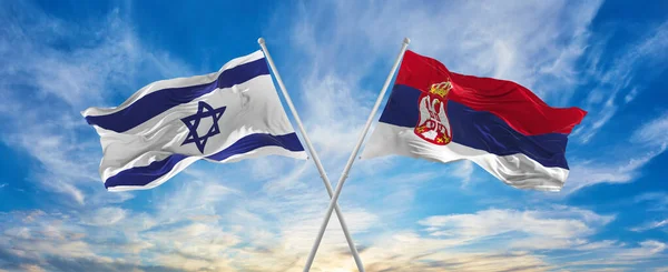 구름낀 하늘에서 이스라엘 국기와 세르비아 국기가 바람에 흔들리고 있었다 관계를 — 스톡 사진