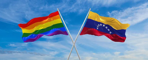 Skrzyżowane Flagi Igbt Wenezueli Machające Wietrze Zachmurzonym Niebie Wolność Miłość — Zdjęcie stockowe