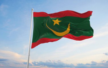 Moritanya 'nın resmi bayrağı bulutlu arka planda gün batımında, panoramik manzara. Vatansever ve seyahat kavramı. Geniş afiş afiş için boşluk kopyala 