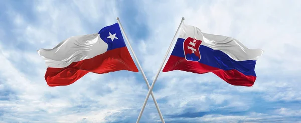 구름낀 하늘에 바람에 흔들리는 칠레와 슬로바키아의 국기를 건넜다 관계를 상징하고 — 스톡 사진