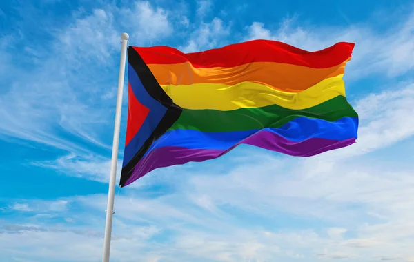 Social Justice Pride flag waving in the wind at cloudy sky. Freedom and love concept. Pride month. activism, community and freedom Concept. Copy space. 3d illustration.