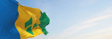 Aziz Vincent ve Grenadine 'in resmi bayrağı bulutlu arka planda, günbatımında, panoramik manzarada. Vatansever ve seyahat kavramı. Geniş afiş afiş için boşluk kopyala. 3d illüstrasyon