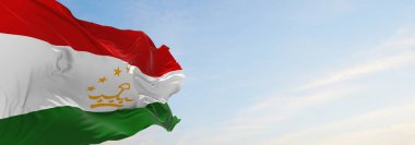 Günbatımında bulutlu arka planda Tacikistan 'ın resmi bayrağı, panoramik manzara. Vatansever ve seyahat kavramı. Geniş afiş afiş için boşluk kopyala. 3d illüstrasyon