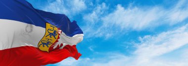 Holstein Holstein 'in bayrağı, hava bulutlu arka planda, günbatımında, panoramik manzara. Almanya Federal Cumhuriyeti. Geniş afiş afiş için boşluk kopyala