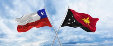 Şili ve Papua Yeni Gine bayraklarını aşıp bulutlu gökyüzünde rüzgarda dalgalanan bayrak. İlişkiyi, diyaloğu, iki ülke arasında seyahat etmeyi sembolize ediyor. Boşluk 3d resimlemesini kopyala