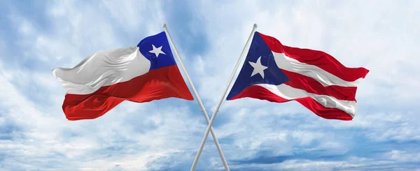구름낀 하늘에서 칠레와 푸에르토리코의 국기가 바람에 흔들리고 있었다 관계를 상징하고 — 스톡 사진