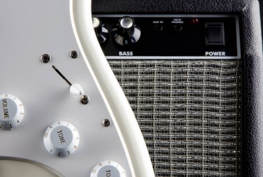 Beyaz elektro gitarın ve yükselticinin yakın görüntüsü