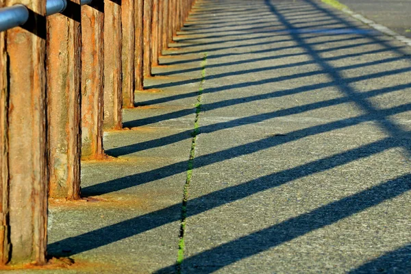 Rusting Safety Barrier Shadows Coastal Jetty Location — Stock Photo, Image