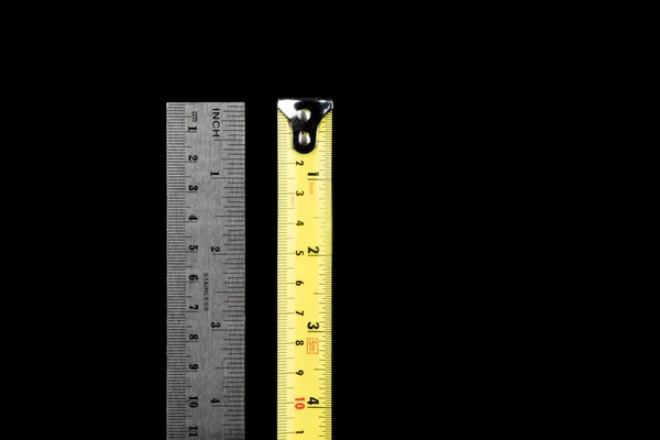Doğru mezura ve mühendisler siyah arka planda izole çelik cetvel.