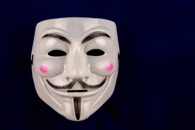 Guy Fawkes koyu mavi arka planda plastik yüz maskesi takıyor.