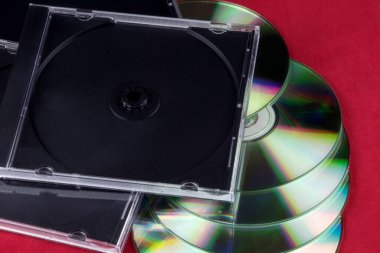 Kırmızı masa yüzeyinde CD ve CD kutuları