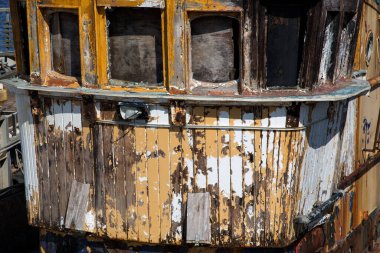 Eski çürüyen balıkçı teknesi liman manzaralı.