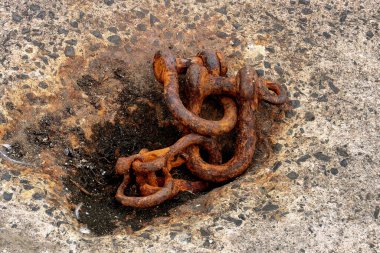 Old disused rusting steel shackles at a coastal harbour location