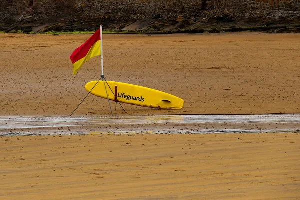 Lifeguard position flag and paddle board at a coastal beach