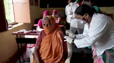 KOLHAPUR-INDIA - 31 Temmuz 2021: Bir tıp çalışanı Kolhapur 'daki köyde Covid-19 Coronavirus aşısı ile bir kadını aşıladı.