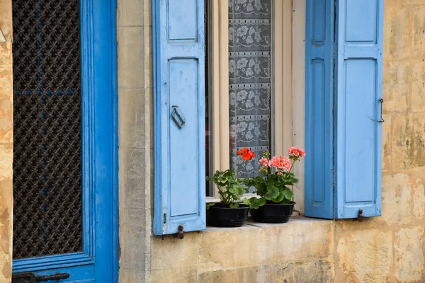 Monpazier, França. Junho de 2016. Feche de uma porta da frente e janela com begônias na armação. — Fotografia de Stock