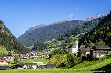 Tyrol, Avusturya. Haziran 2016. Arka planda karla kaplı dağ zirveleri olan vadideki Tyrolean köyü.