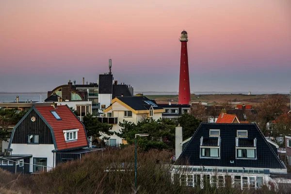 Huisduinen, the Netherlands. january 2022. Setting sun over the village and the lighttower. — Stock Photo, Image