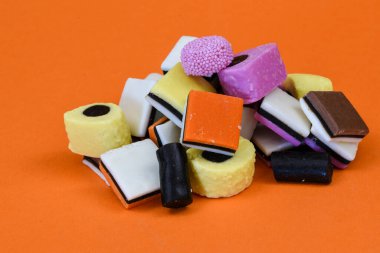 Den Helder, Hollanda. Ocak 2022. Turuncu arka planda farklı renklerde İngiliz meyankökü çeşitleri.