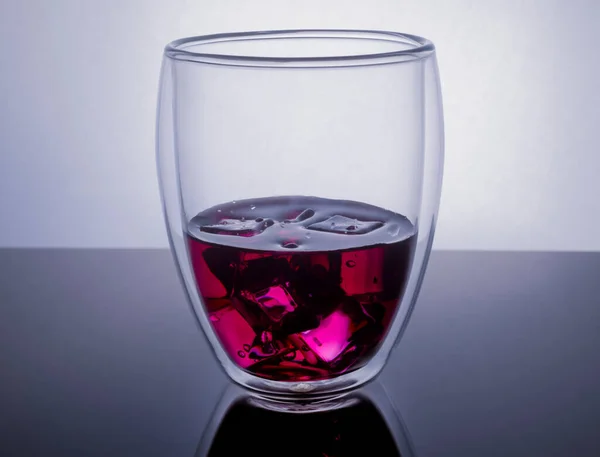 Copo Vidro Transparente Com Suco Roxo Cubos Gelo Fundo Reflexivo — Fotografia de Stock