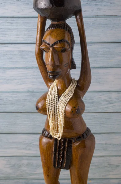 Afrika Woodoo heykeli, inci kolyeli kadın. Mavi panoların arkaplanı