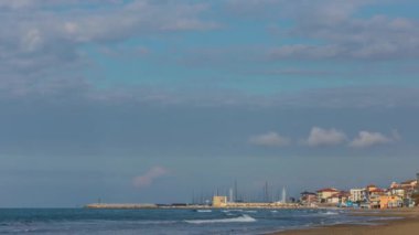 Turizm limanındaki deniz ve bulutlar ile Toskana 'daki San Vincenzo şehrinin tarihi merkezi arasındaki zaman kaybı