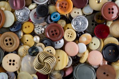 Çeşitli şekil ve boyutlarda bir sürü eski renkli düğme. Düz düzen, üst görünüm