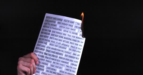 Male hand holding a burning sheet of paper, slow motion — Stock Video