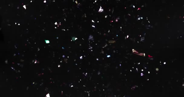 Glänsande konfetti faller på svart bakgrund — Stockvideo