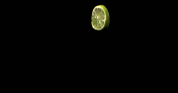 Cunhas de limão cortadas em anéis caem em um fundo preto — Vídeo de Stock