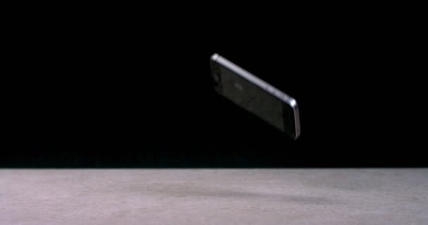Telefon komórkowy spada, odbija się od powierzchni i jest przyznawany na ekranie — Wideo stockowe