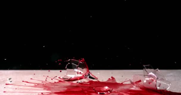 A glass of red wine falls, breaking into shards and splashing the contents — Stock Video