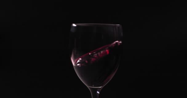 O vinho tinto brilha em um copo, criando belas ondas — Vídeo de Stock