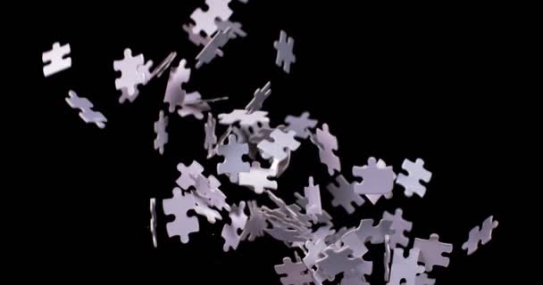 White puzzle pieces falling down whirling in slow motion — Stock Video