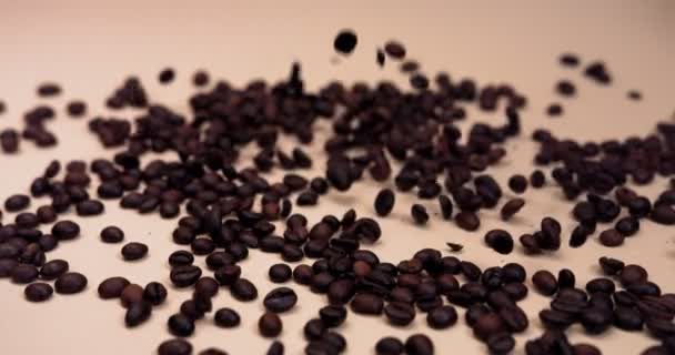 Kávová zrna padají na stůl, poskakují a rozhazují — Stock video