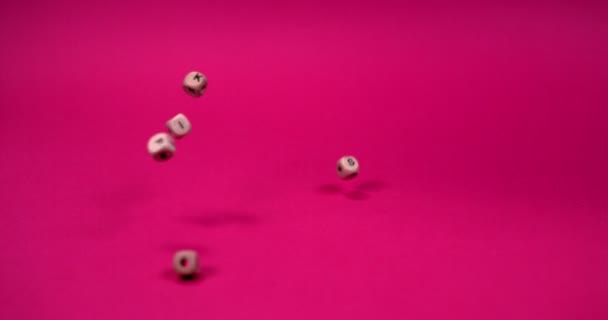 Braune Perlen in Form eines Quadrats mit darauf geschriebenen Buchstaben fallen herab — Stockvideo