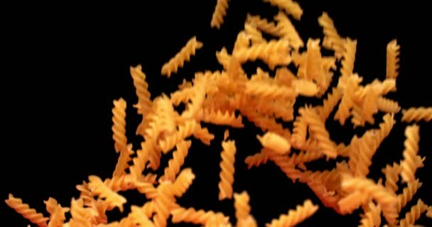 Rauwe pasta in de vorm van een spiraal vliegen omhoog en naar beneden vallen — Stockvideo