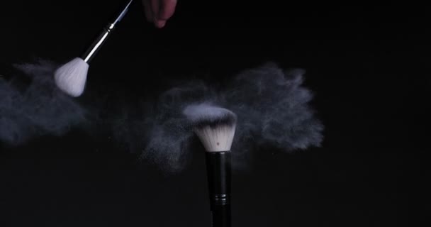 Cleaning the makeup brush with another brush, the remains of powder scatter — Stock Video